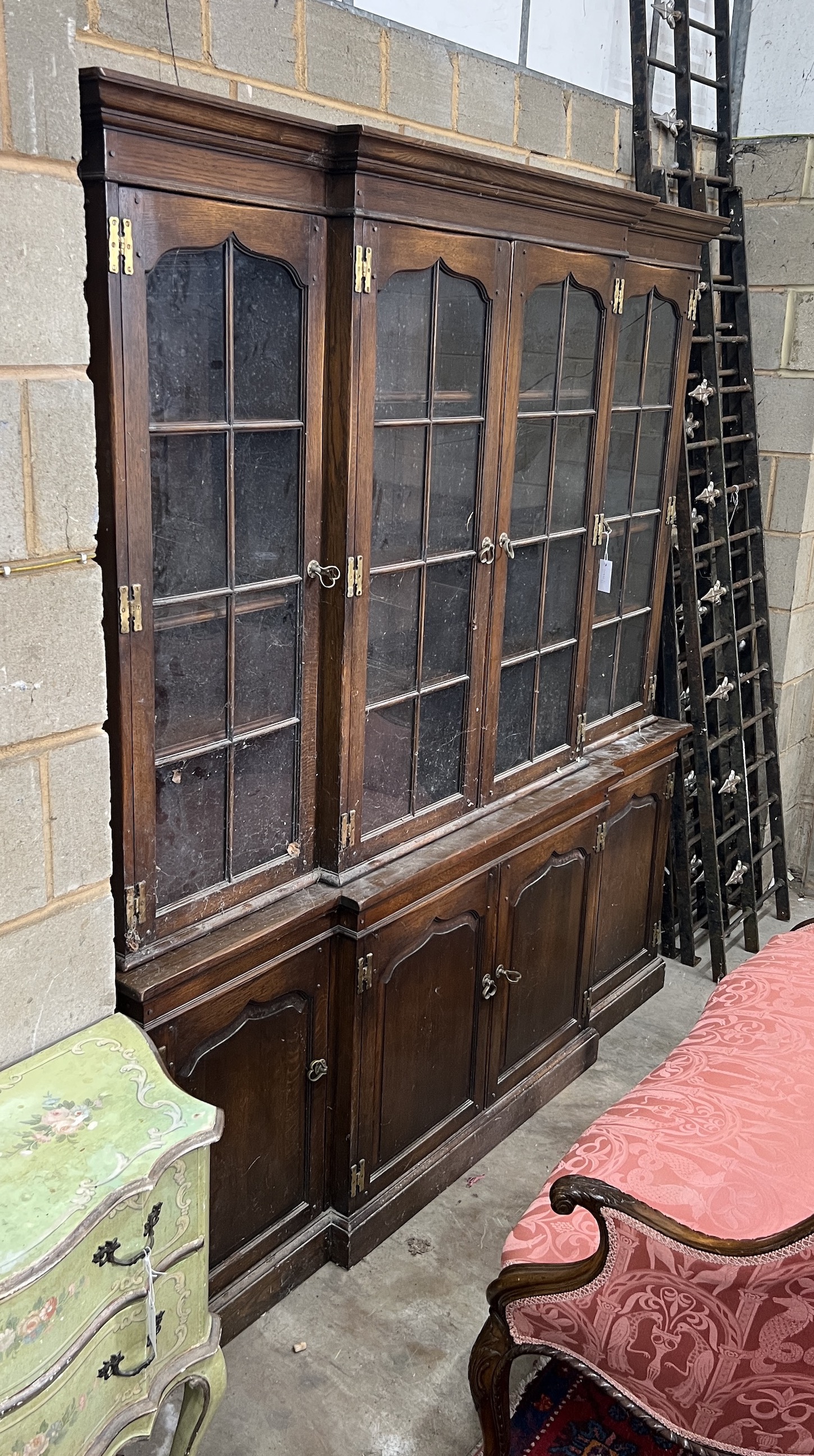 A reproduction oak breakfront library bookcase, length 186cm, depth 38cm, height 196cm